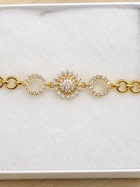 Gold open circle bracelet with CZ flower and circle pave accents